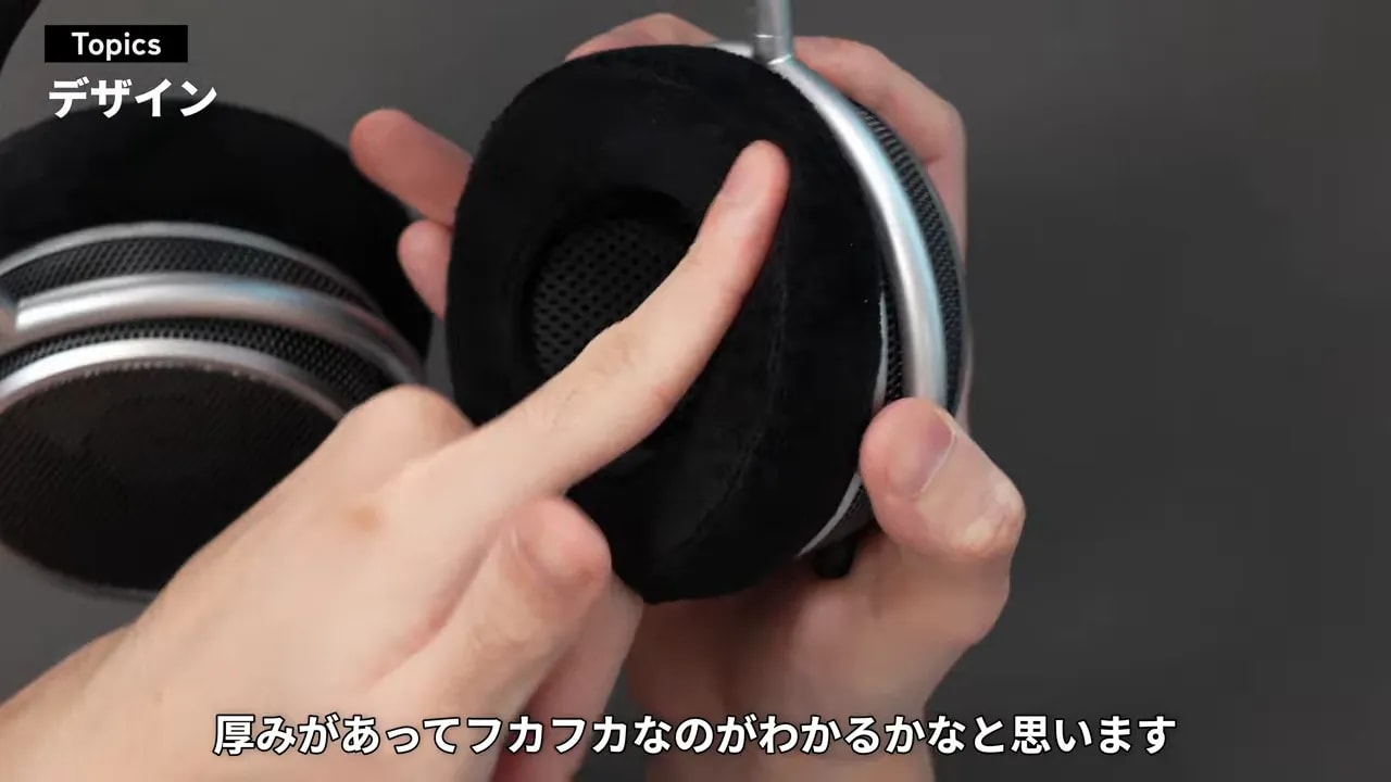 厚みのある黒いベロアイヤーパッドを指で押している様子